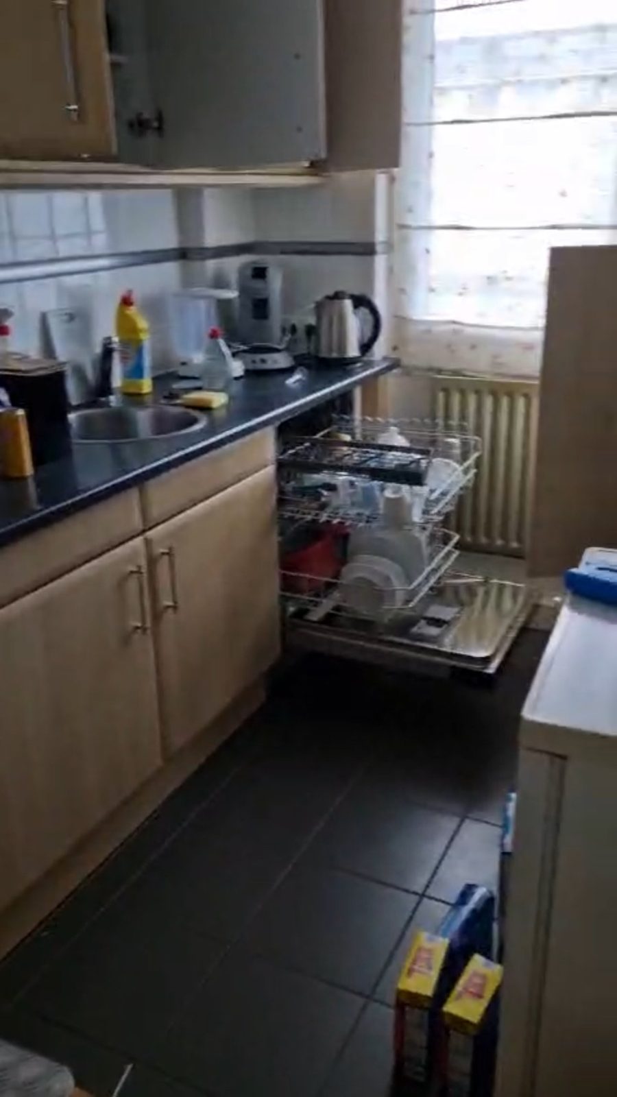 Keuken met volle aanrechtbladen en geopende vaatwasser vóór de ontruiming